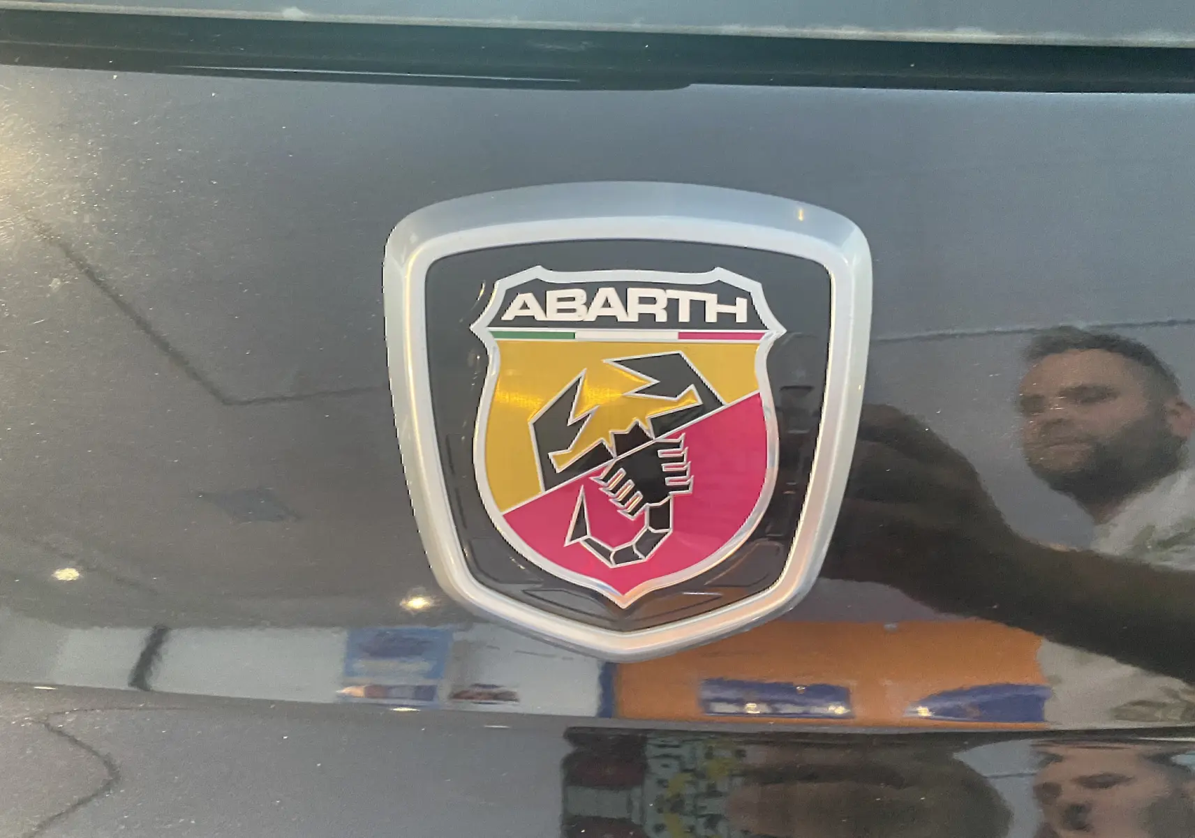 Gros plan sur le logo Abarth noir et rouge sur la calandre d'une ABARTH 595 noire de 2018.