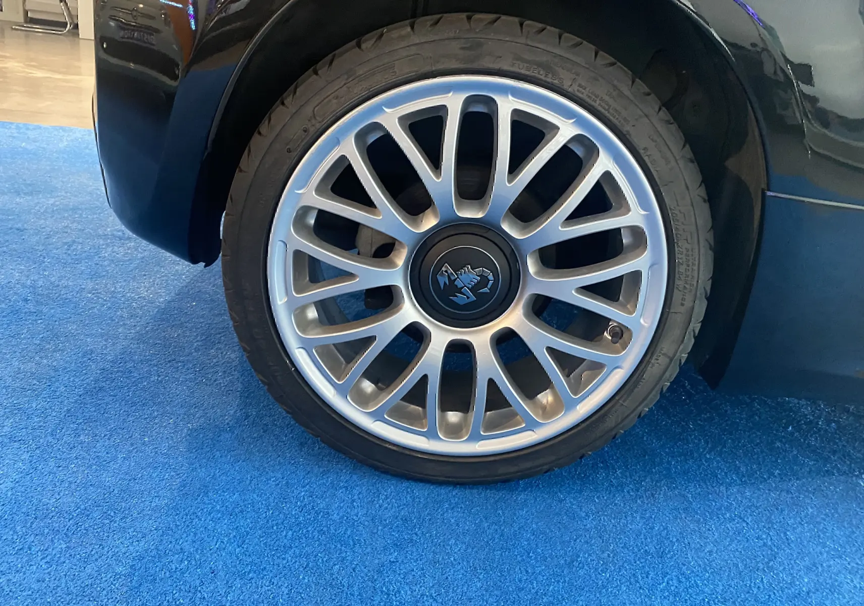 Gros plan sur la jante alu 17 pouces argentée avec logo Abarth d'une roue avant droite d'une ABARTH 595 noire.