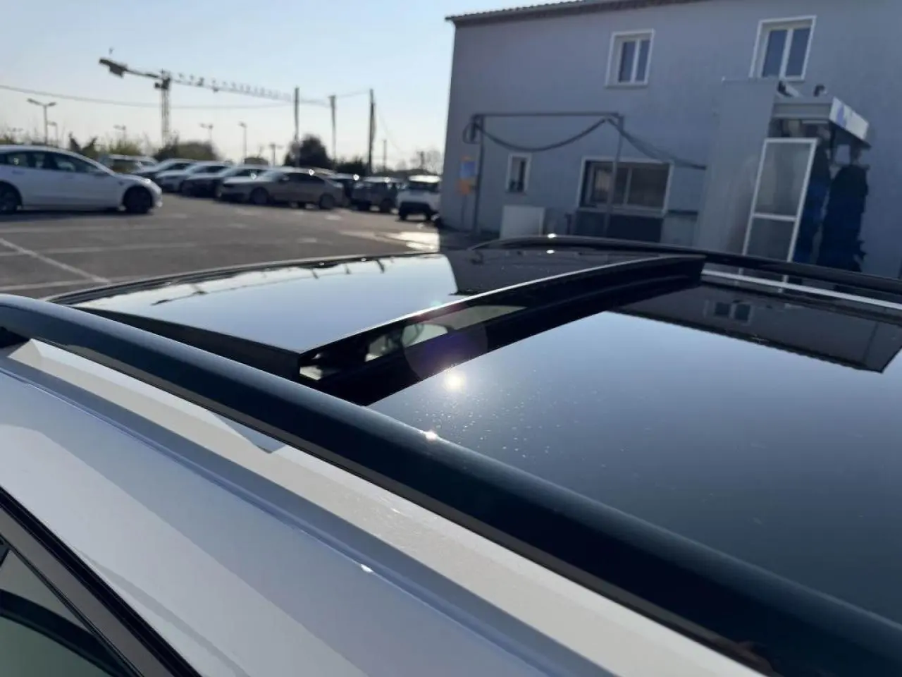 Toit ouvrant panoramique noir sur SUV CUPRA Formentor blanc nacré vu de dessus côté gauche.