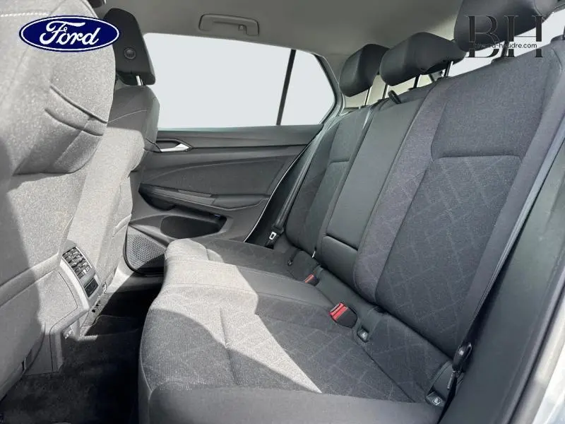 Vue intérieure côté droit de la banquette arrière gris foncé de la Volkswagen Golf 2023 avec appuie-têtes et ceintures visibles.