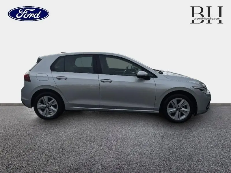 Vue de profil côté gauche d'une Volkswagen Golf gris lunaire 2023, avec jantes alliage et poignées ton carrosserie.