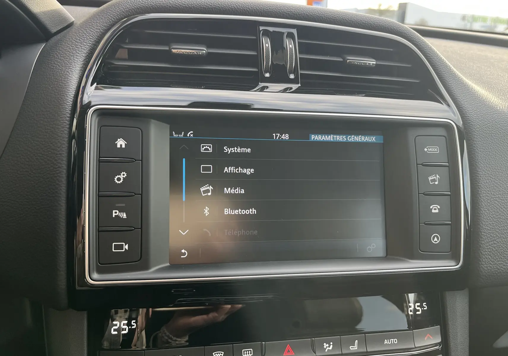 Vue rapprochée de l’écran tactile central et des commandes noires du tableau de bord du Jaguar F-PACE blanc 2018.