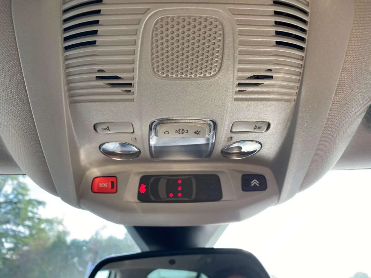 Vue en contre-plongée du plafonnier beige avec commandes d’éclairage et bouton SOS du Citroën C5 Aircross blanc.