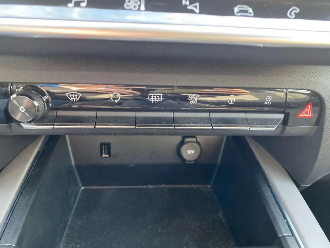 Gros plan sur la console centrale du Citroën C5 Aircross 2021, montrant les commandes de climatisation et une prise 12V.