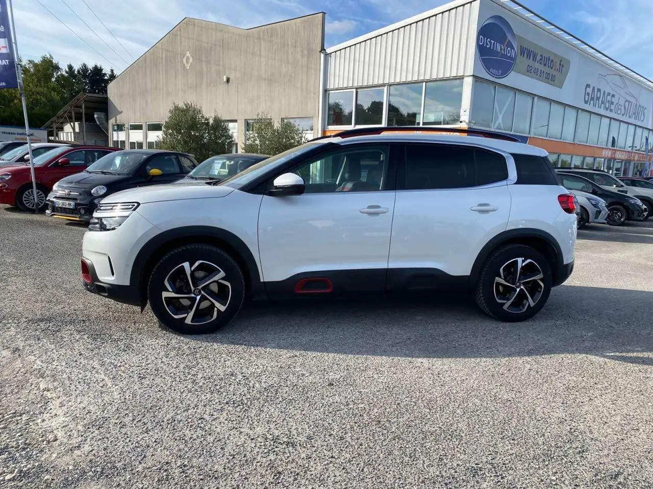 Profil côté gauche d’un Citroën C5 Aircross blanc nacré avec inserts Deep Red et jantes diamantées bi-ton.
