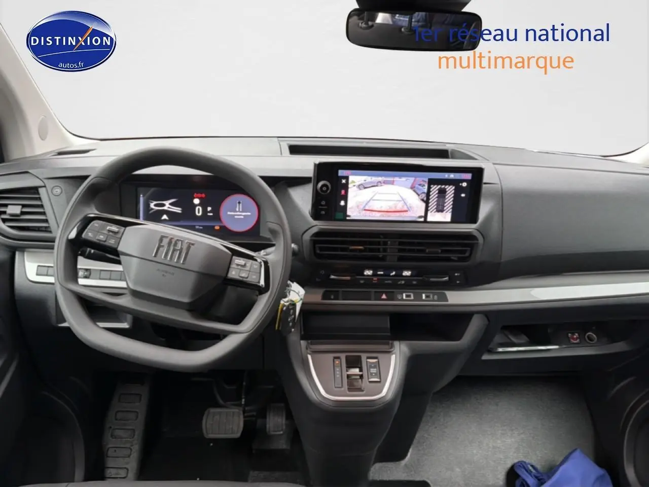 Vue intérieure avant du Fiat Scudo Combi gris titane, tableau de bord moderne avec écran tactile et volant multifonction.