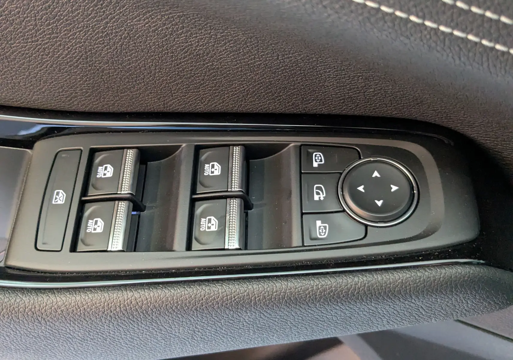 Commande des vitres électriques et réglage des rétroviseurs sur la porte côté gauche d’un Renault Austral blanc nacré.