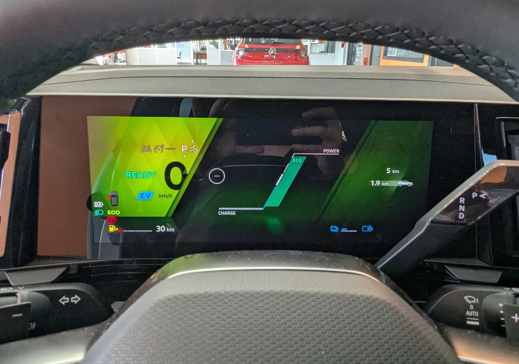 Vue intérieure du tableau de bord numérique du Renault Austral E-Tech 200 Esprit Techno avec affichage hybride et indicateurs verts.