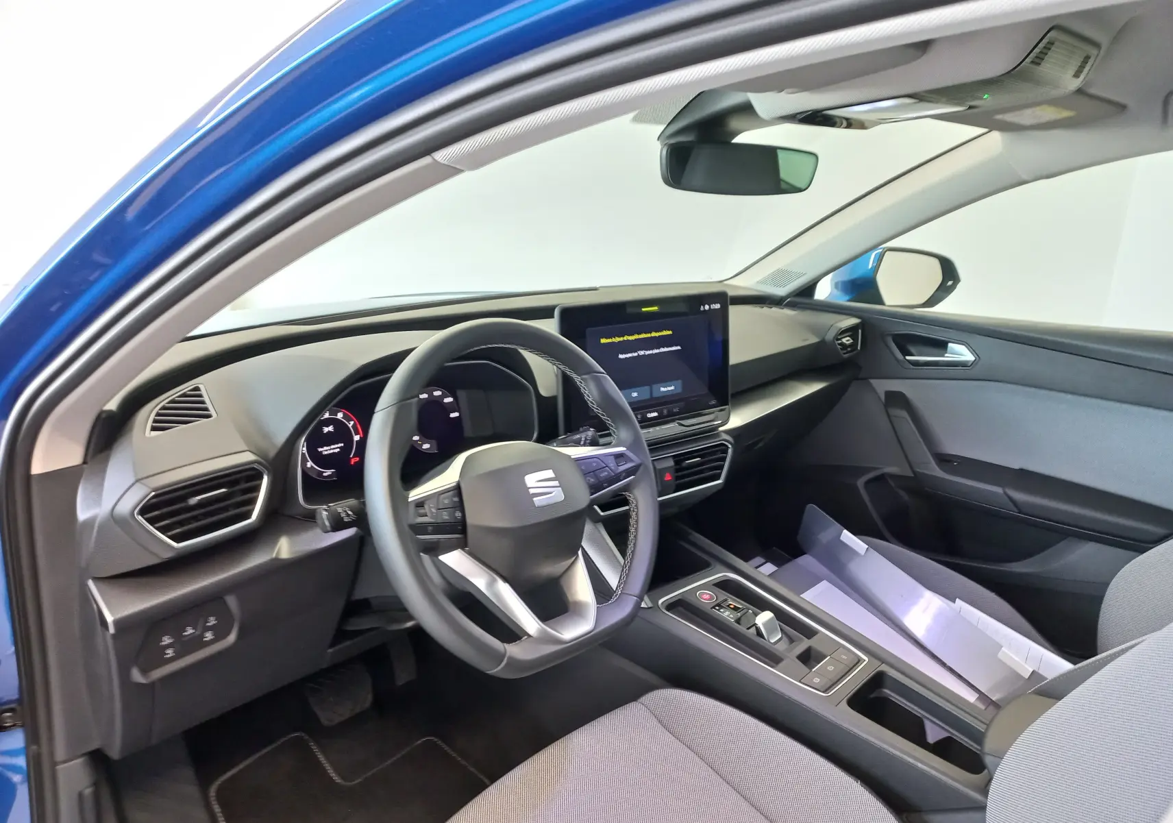 Intérieur de la SEAT LEON 1.5 eTSI 115 DSG7 Copa vue côté conducteur, tableau de bord moderne avec écran tactile central.