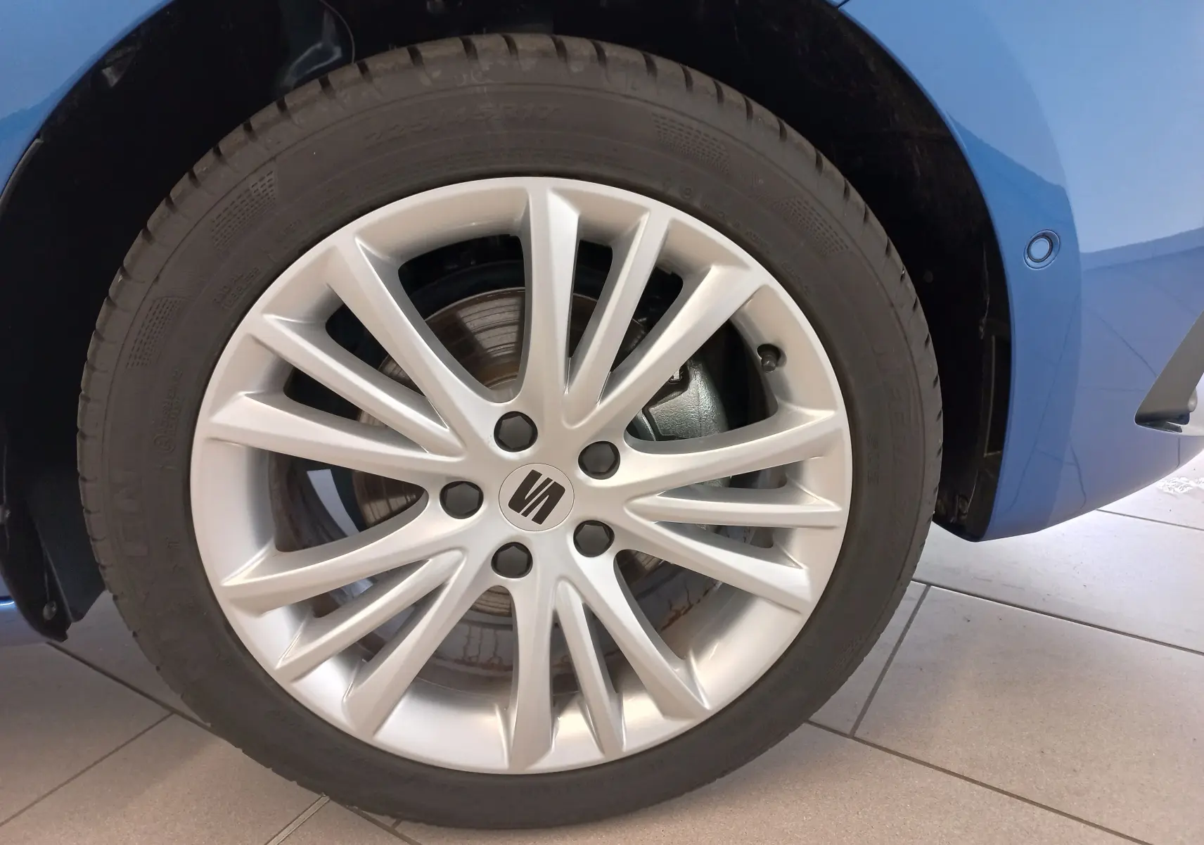 Gros plan sur la roue avant droite de la SEAT LEON Bleu Saphir, mettant en valeur la jante alliage argentée.