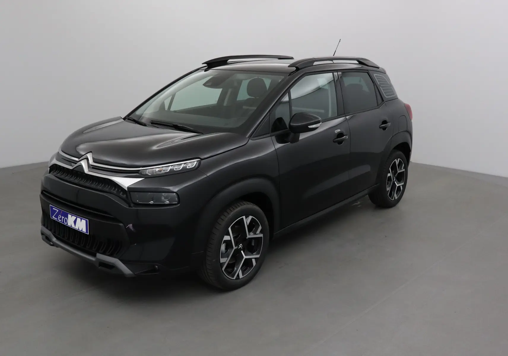 Citroën C3 Aircross noir vue 3/4 avant droit, avec jantes alliage et barres de toit noires.