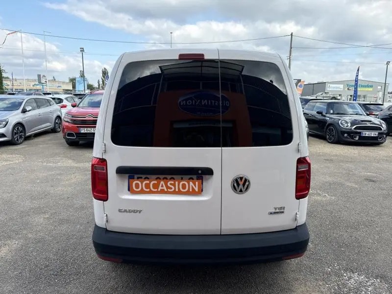 Vue arrière d'un Volkswagen Caddy Van blanc Candy avec portes arrière vitrées et plaque "OCCASION" visible.
