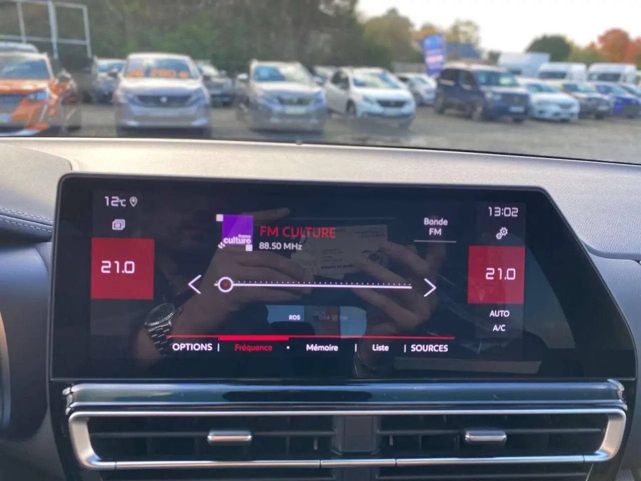 Vue du tableau de bord du Citroën C5 Aircross 2025 avec écran tactile affichant la radio FM et commandes climatisation.