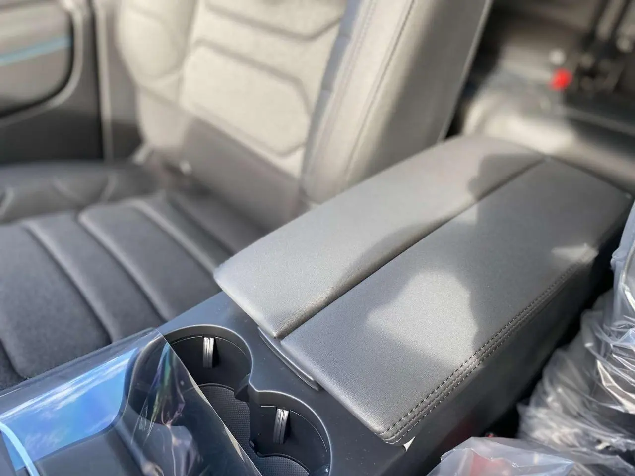 Gros plan sur l'accoudoir central arrière en cuir gris du Citroën C5 Aircross 2025 noir Perla.