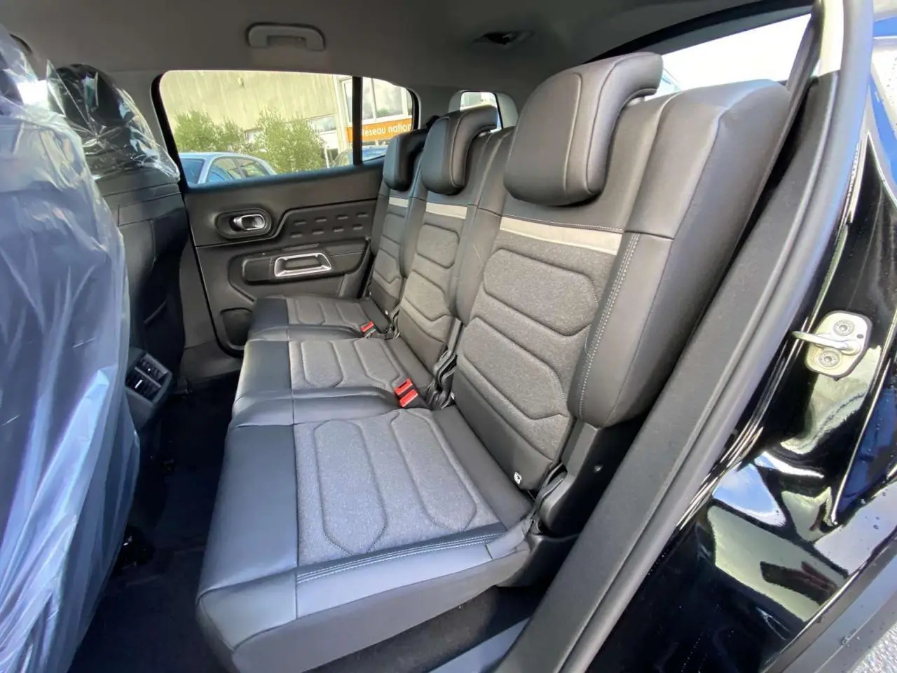 Vue latérale des sièges arrière en cuir et tissu gris du Citroën C5 Aircross noir perla avec porte ouverte côté droit.