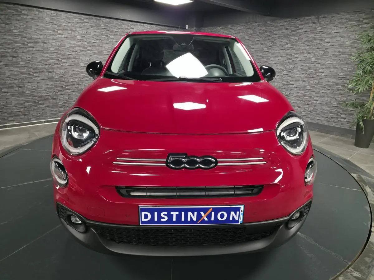 Vue frontale d'une Fiat 500X rouge vif avec phares LED ronds et logo 500 bien visible sur calandre noire.