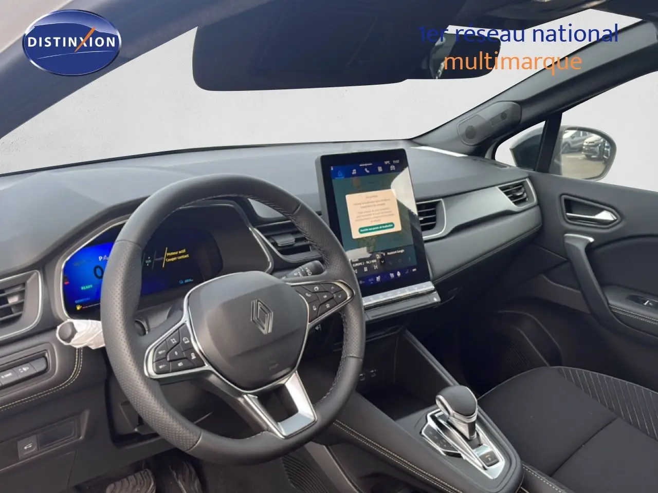 Vue intérieure côté conducteur du Renault Symbioz blanc nacré, avec tableau de bord numérique et écran tactile vertical.