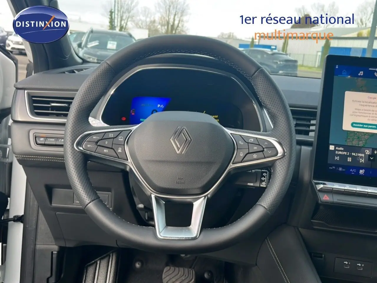 Vue intérieure centrée sur le volant en cuir noir et le tableau de bord numérique de la Renault Symbioz blanche nacrée 2025.