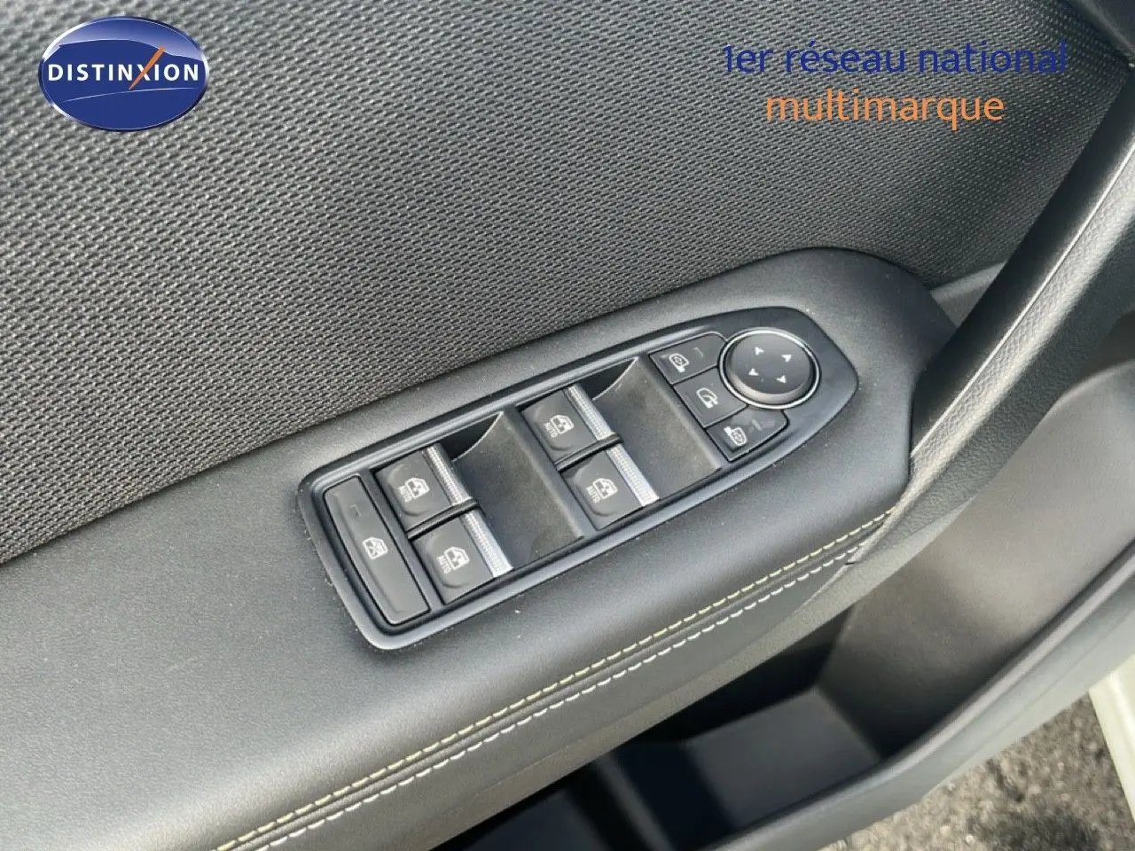 Gros plan sur les commandes des vitres électriques côté conducteur d’une Renault Symbioz blanc nacré 2025.