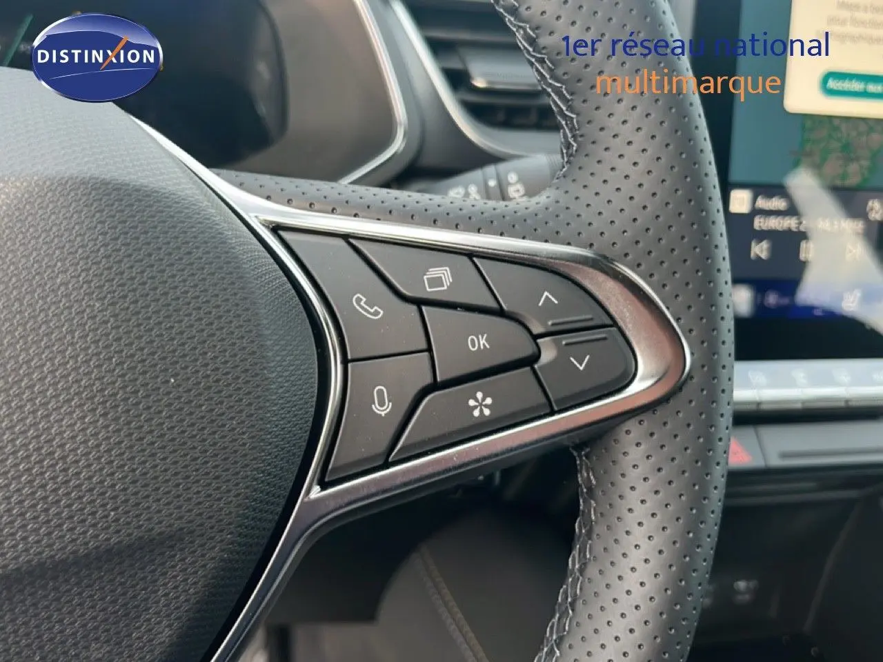 Détail du volant en cuir perforé avec commandes multifonctions, intérieur du Renault Symbioz blanc nacré 2025.