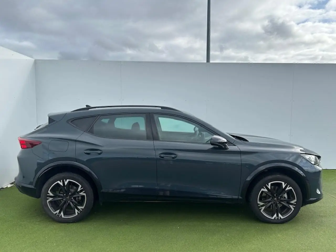 Profil côté gauche du CUPRA Formentor gris Fiord Metal avec jantes alliage 18 pouces et toit noir piano.