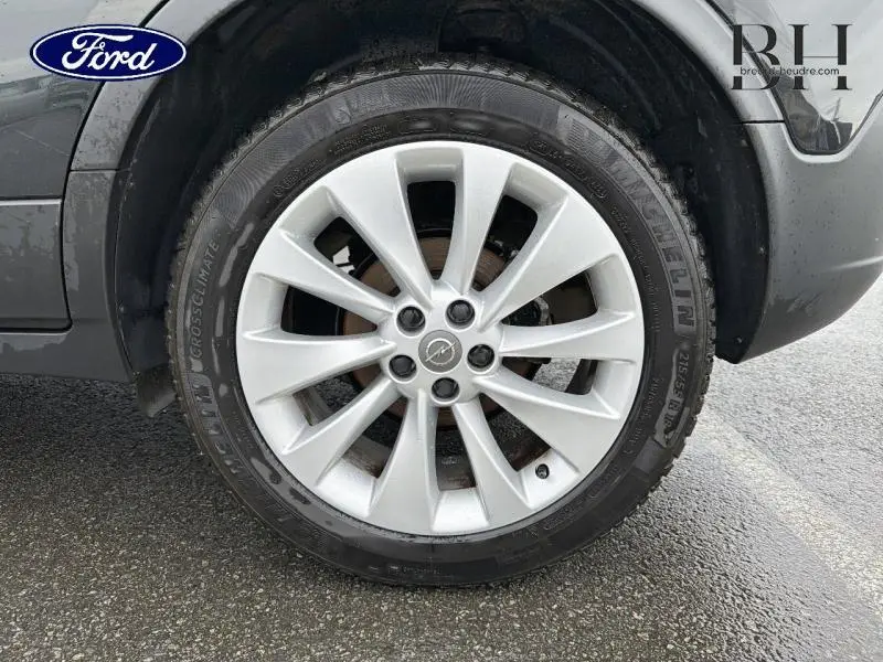 Gros plan sur la roue avant gauche d'un Opel Mokka noir carbone, mettant en valeur la jante alu à dix branches.