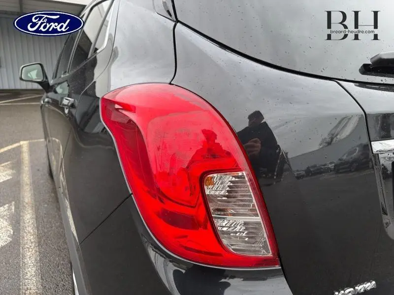 Gros plan sur le feu arrière droit d'un Opel Mokka noir carbone, avec reflet sur la carrosserie brillante.