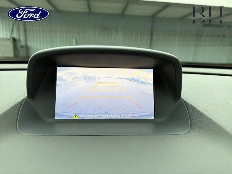 Écran de caméra de recul affichant l'arrière du véhicule dans un habitacle Ford, vue frontale du tableau de bord.