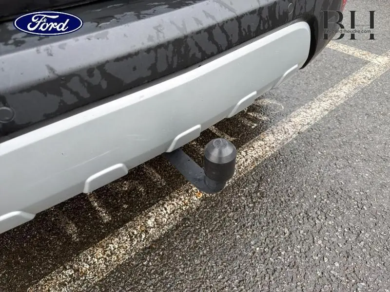 Gros plan sur l'attelage arrière d'un Opel Mokka noir carbone, montrant le pare-chocs et la boule d'attelage.