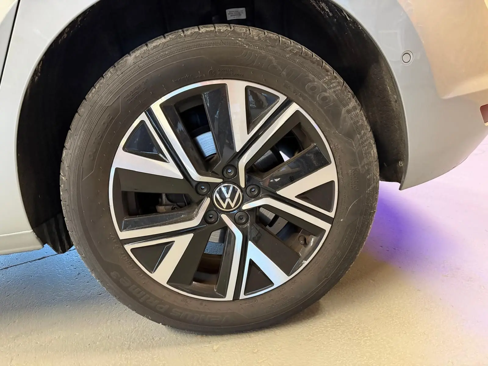 Gros plan sur la roue arrière droite gris clair du Volkswagen Touran 2.0 TDI avec jante alliage noire et argentée Alexandria.