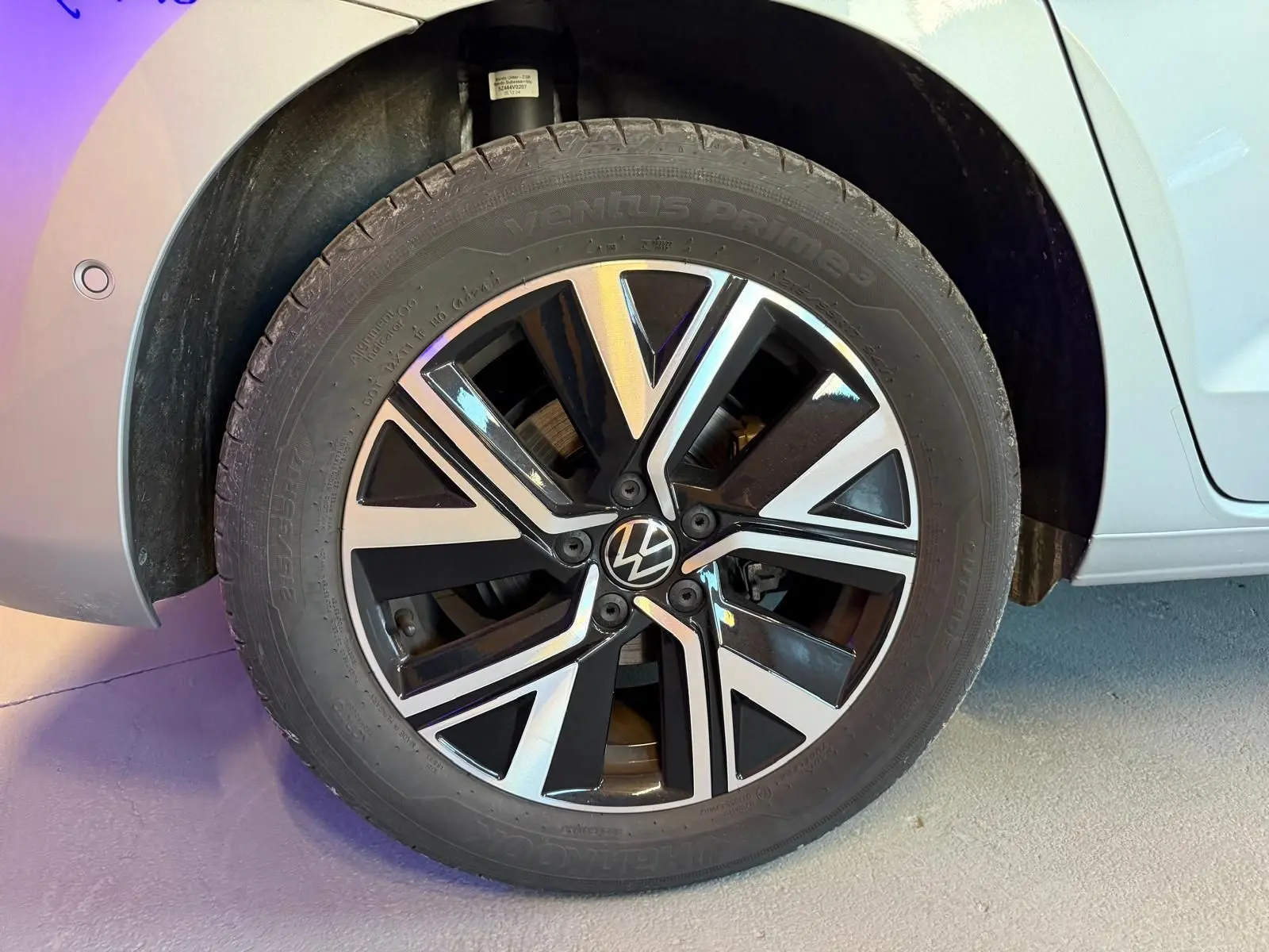 Gros plan sur la jante alliage noire et argentée du côté arrière droit d’un Volkswagen Touran gris 2025.
