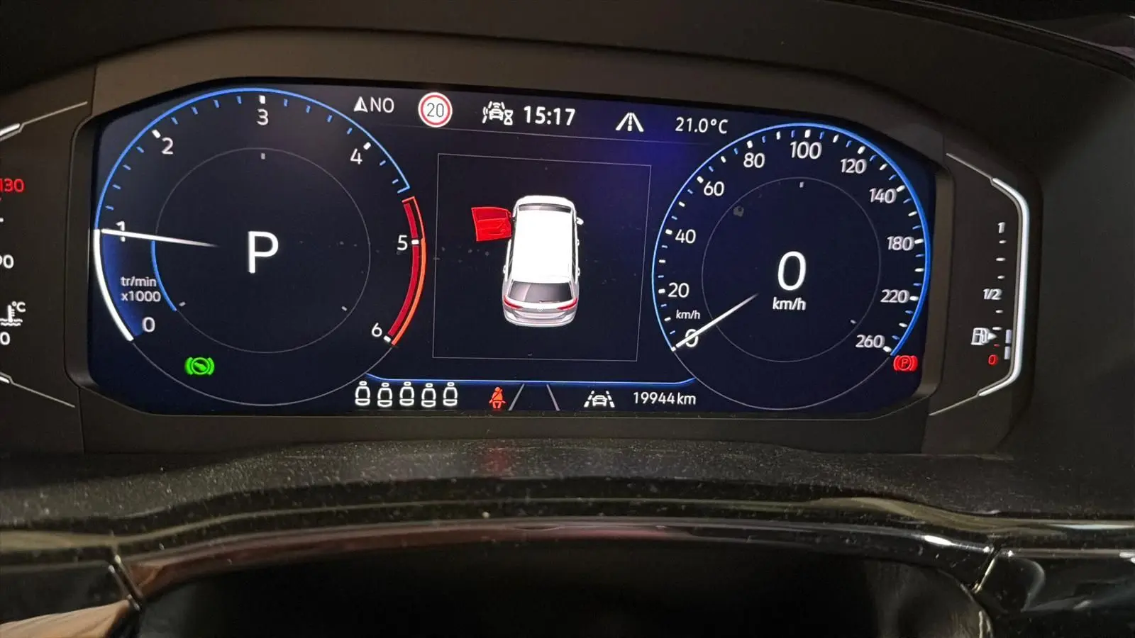Tableau de bord numérique du Volkswagen Touran 2.0 TDI gris, affichant la vitesse à 0 km/h et porte arrière gauche ouverte.