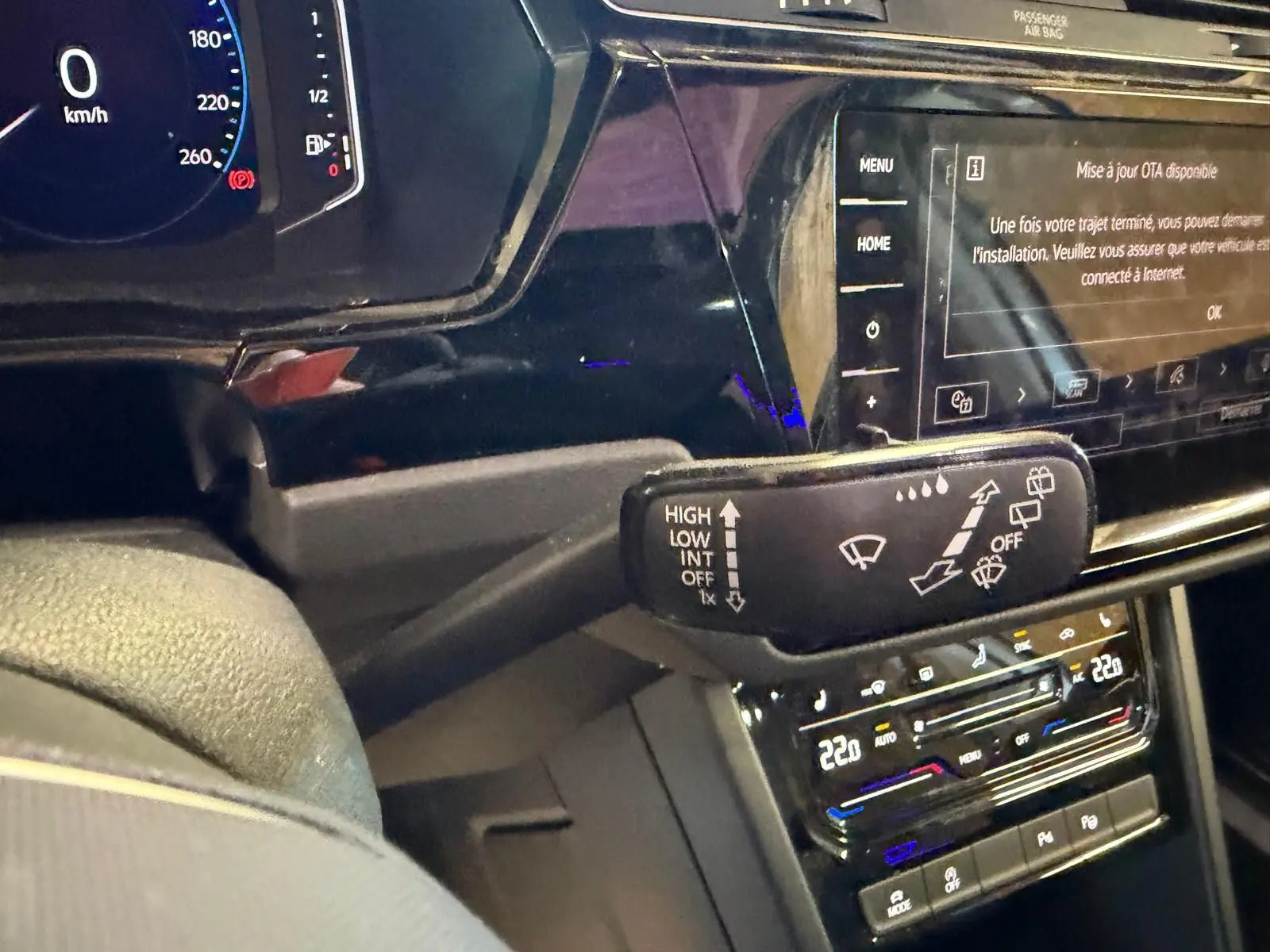 Vue intérieure rapprochée du tableau de bord noir du Volkswagen Touran 2025, avec commandes d’essuie-glace et écran tactile.