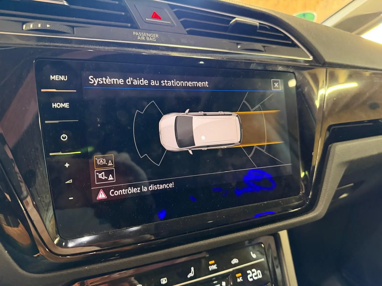 Écran tactile intérieur du Volkswagen Touran 2025 affichant l'aide au stationnement avec alertes de distance.