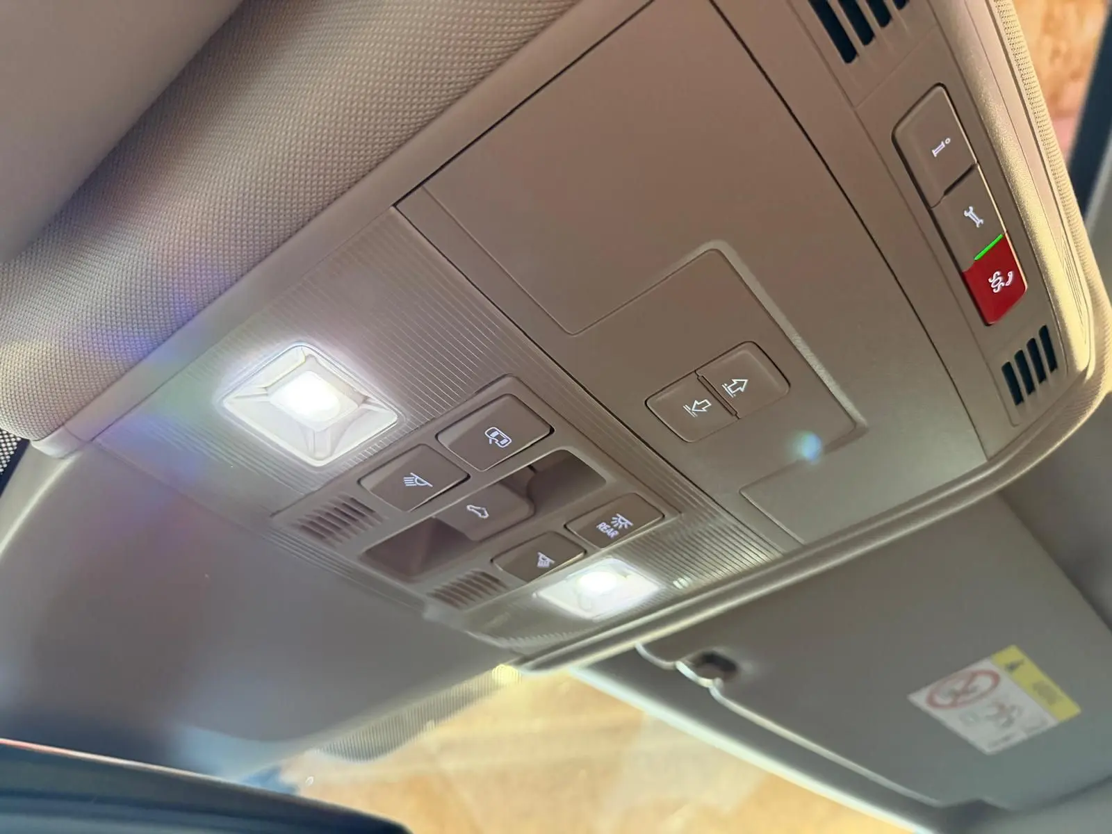 Vue intérieure en plongée du panneau de commandes de toit ouvrant et éclairage dans un Volkswagen Touran gris.