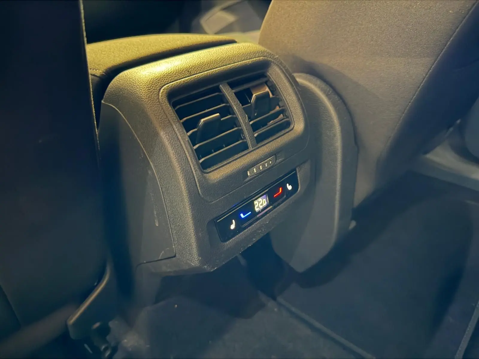 Détail de la console arrière avec commandes de climatisation et sièges chauffants dans un Volkswagen Touran gris.