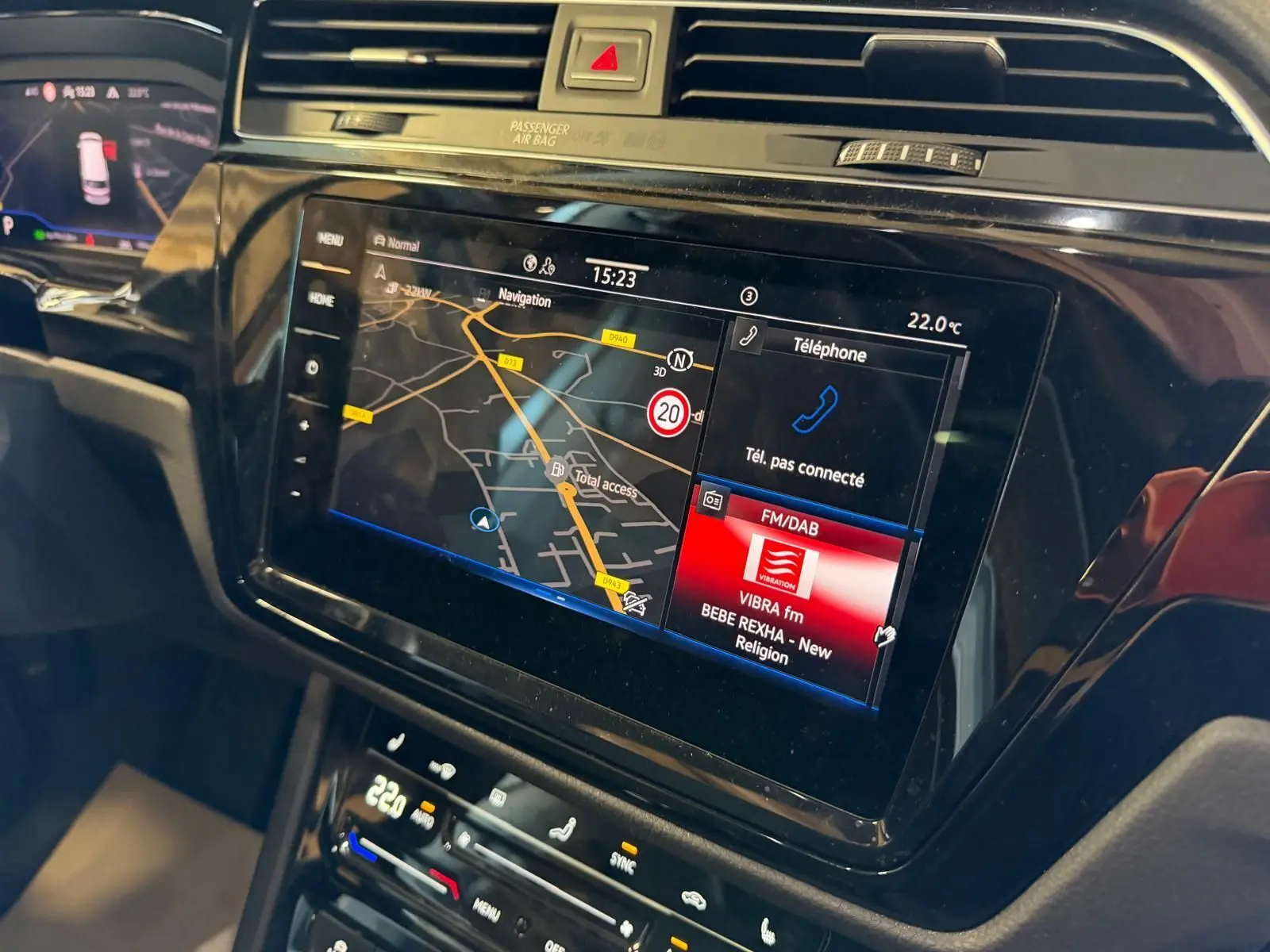Vue rapprochée de l'écran tactile central du Volkswagen Touran 2025, affichant navigation et radio FM/DAB.
