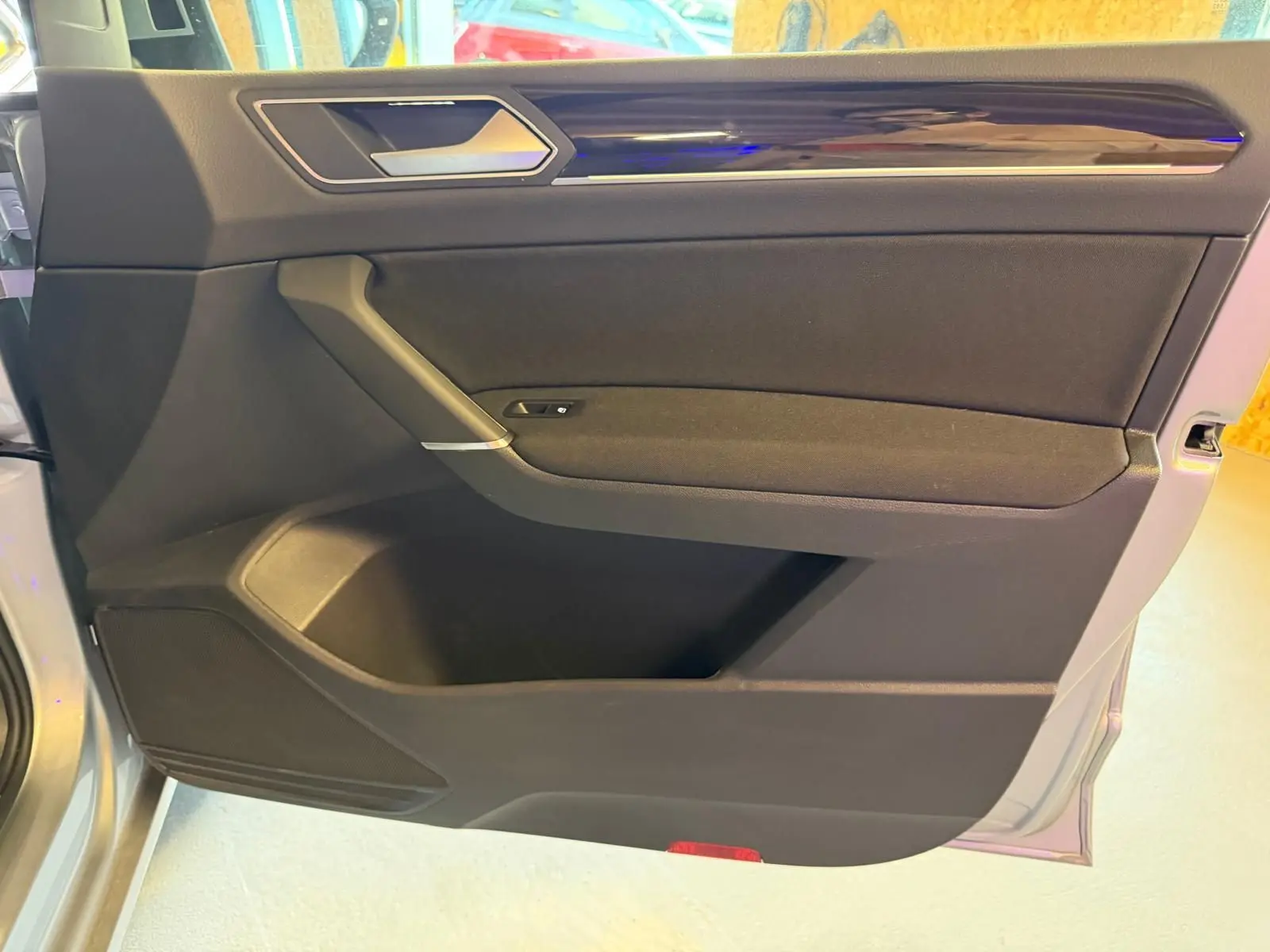 Vue rapprochée de la porte avant gauche grise du Volkswagen Touran 2025 avec garniture noire et insert chromé.