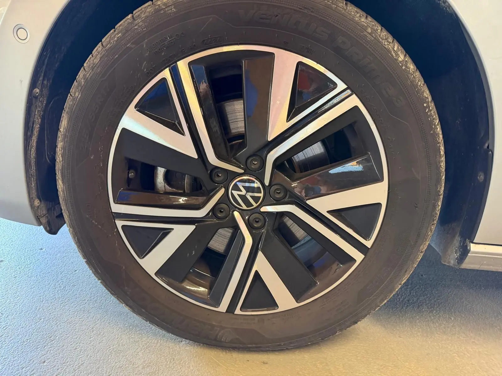 Gros plan sur la jante alliage noire et argentée « Alexandria » 17 pouces du Volkswagen Touran gris 2025 côté avant droit.