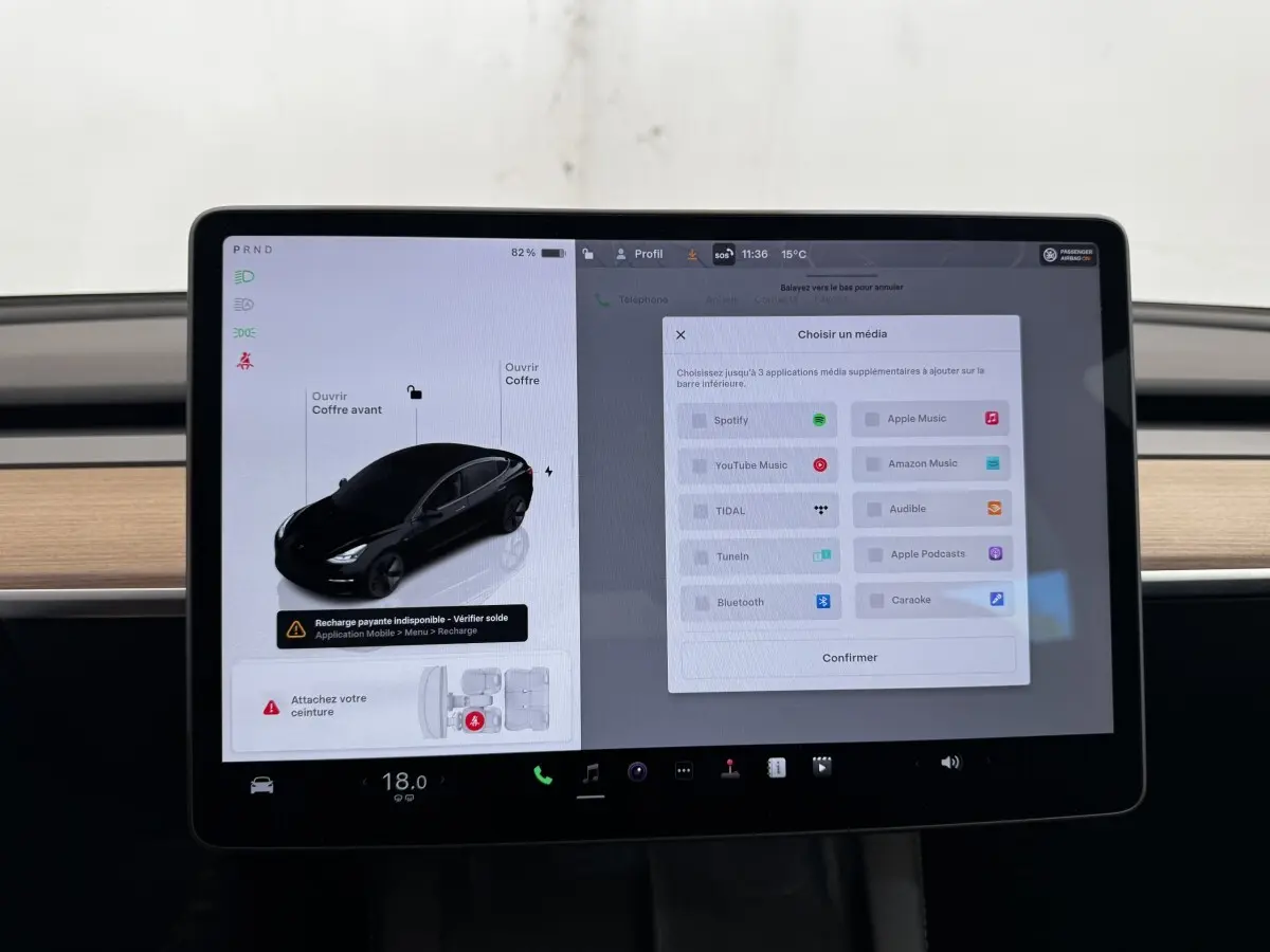 Écran tactile central de la Tesla Model 3 Grande Autonomie 2023 affichant les options multimédias et l'état du véhicule noir.