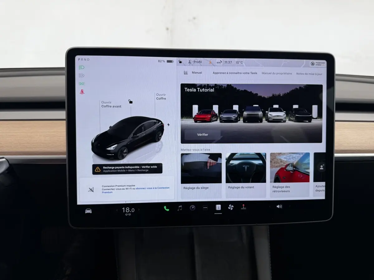 Écran tactile central affichant l'interface de contrôle d'une Tesla Model 3 noire, version Grande Autonomie, 2023.