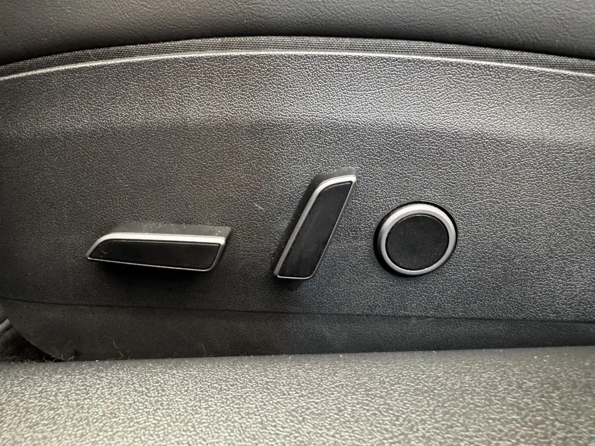 Détail des commandes électriques de réglage de siège noir dans une Tesla Model 3 Grande Autonomie 2023.