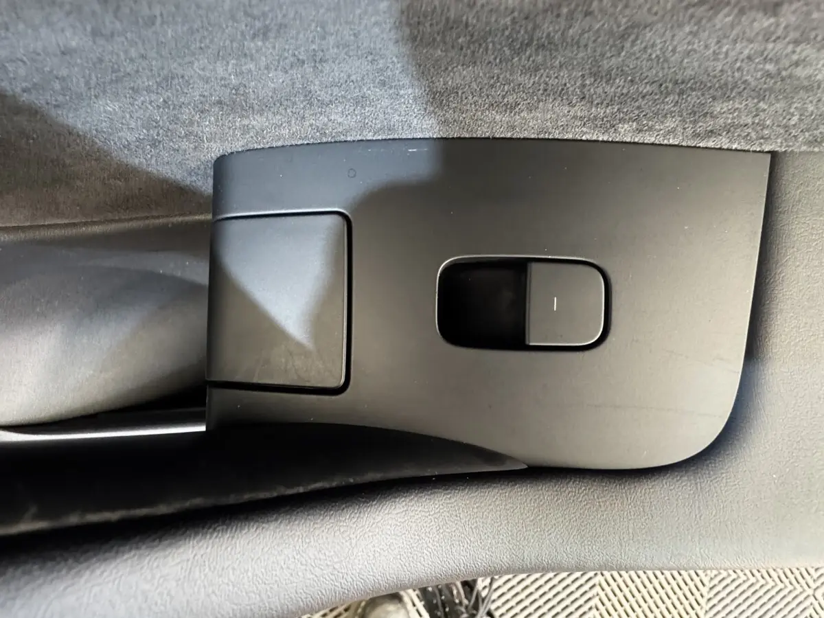 Gros plan sur le bouton de réglage électrique du siège côté conducteur intérieur d'une Tesla Model 3 noire 2023.