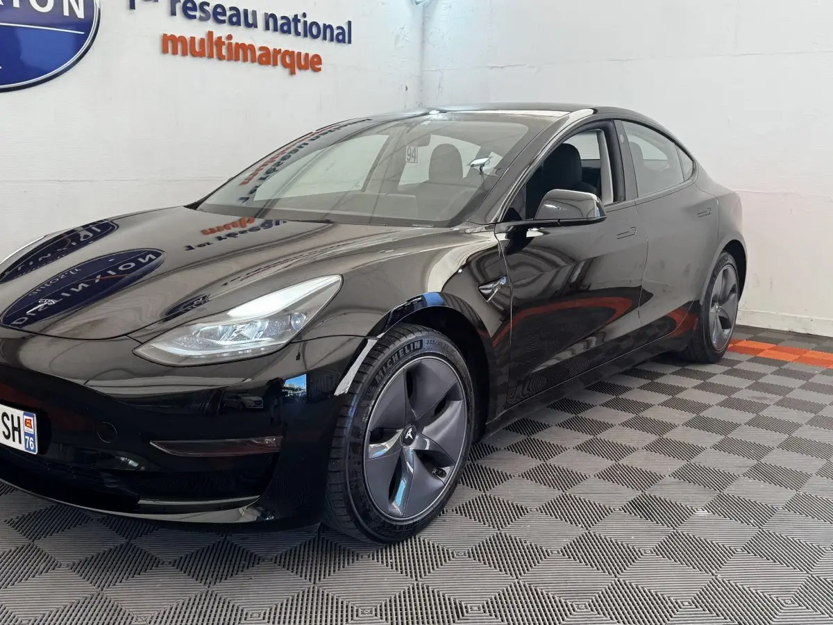 Tesla Model 3 Grande Autonomie noir, vue 3/4 avant droit, jantes aérodynamiques et phares LED visibles.