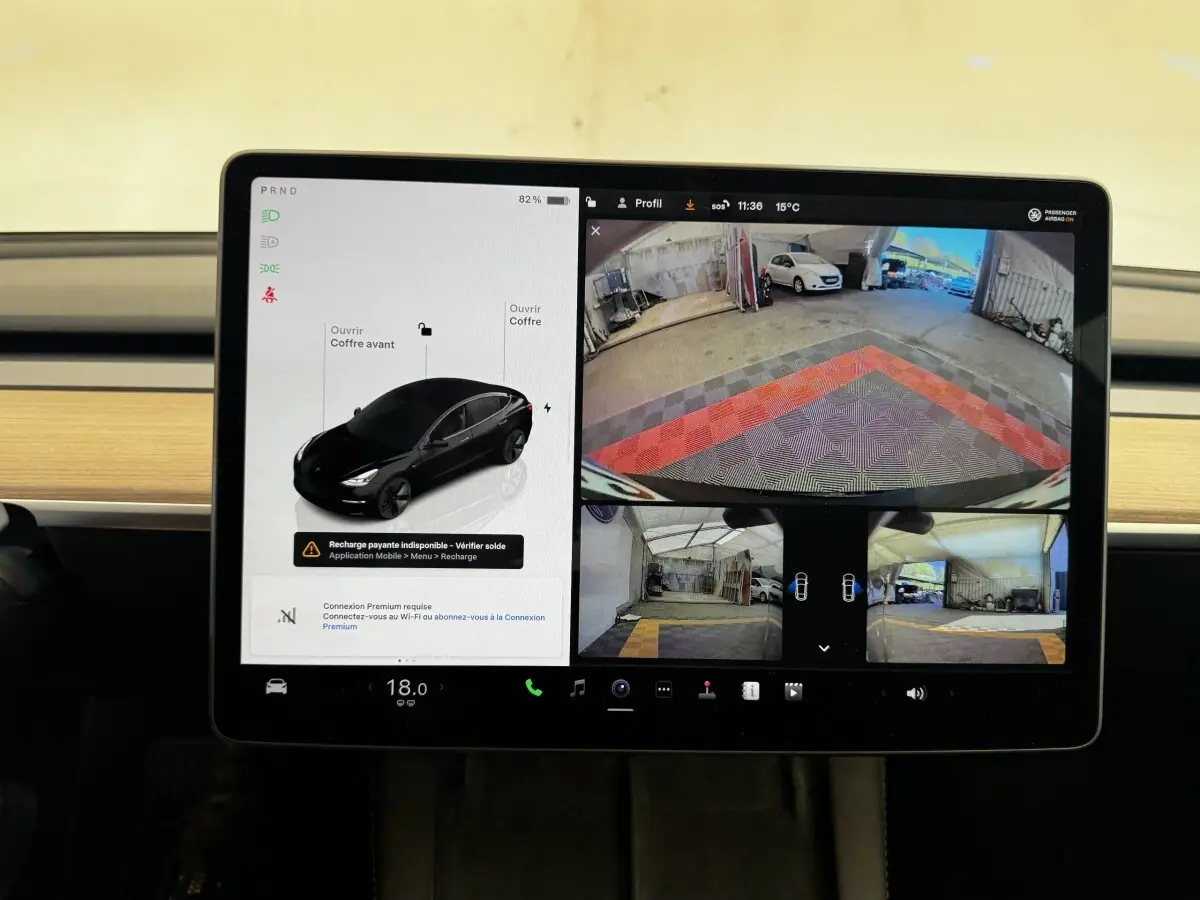 Écran tactile central de Tesla Model 3 noir 2023 montrant la vue caméra arrière et l’interface de contrôle du véhicule.