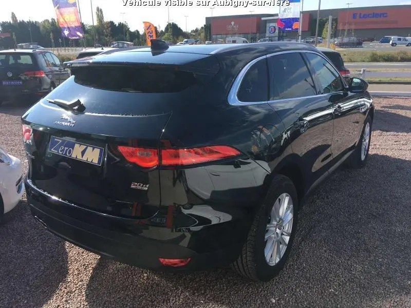 Jaguar F-PACE noir vue 3/4 arrière droit, jantes argentées et vitres surteintées en extérieur.