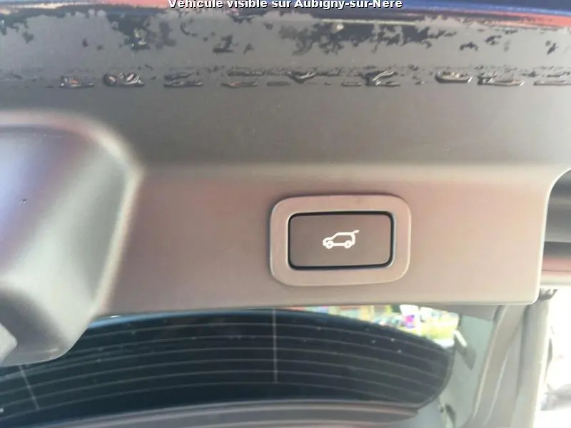 Bouton d'ouverture électrique du coffre sur la partie intérieure du hayon d'un Jaguar F-PACE noir.