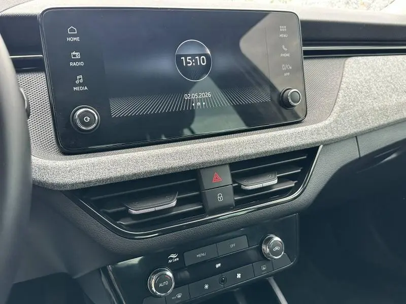 Vue intérieure du tableau de bord du Skoda Scala blanc cristal 2025, avec écran tactile et commandes de climatisation.