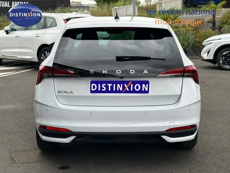 Vue arrière d'une Skoda Scala blanche Cristal avec feux arrière LED et logo SKODA centré sur le hayon.