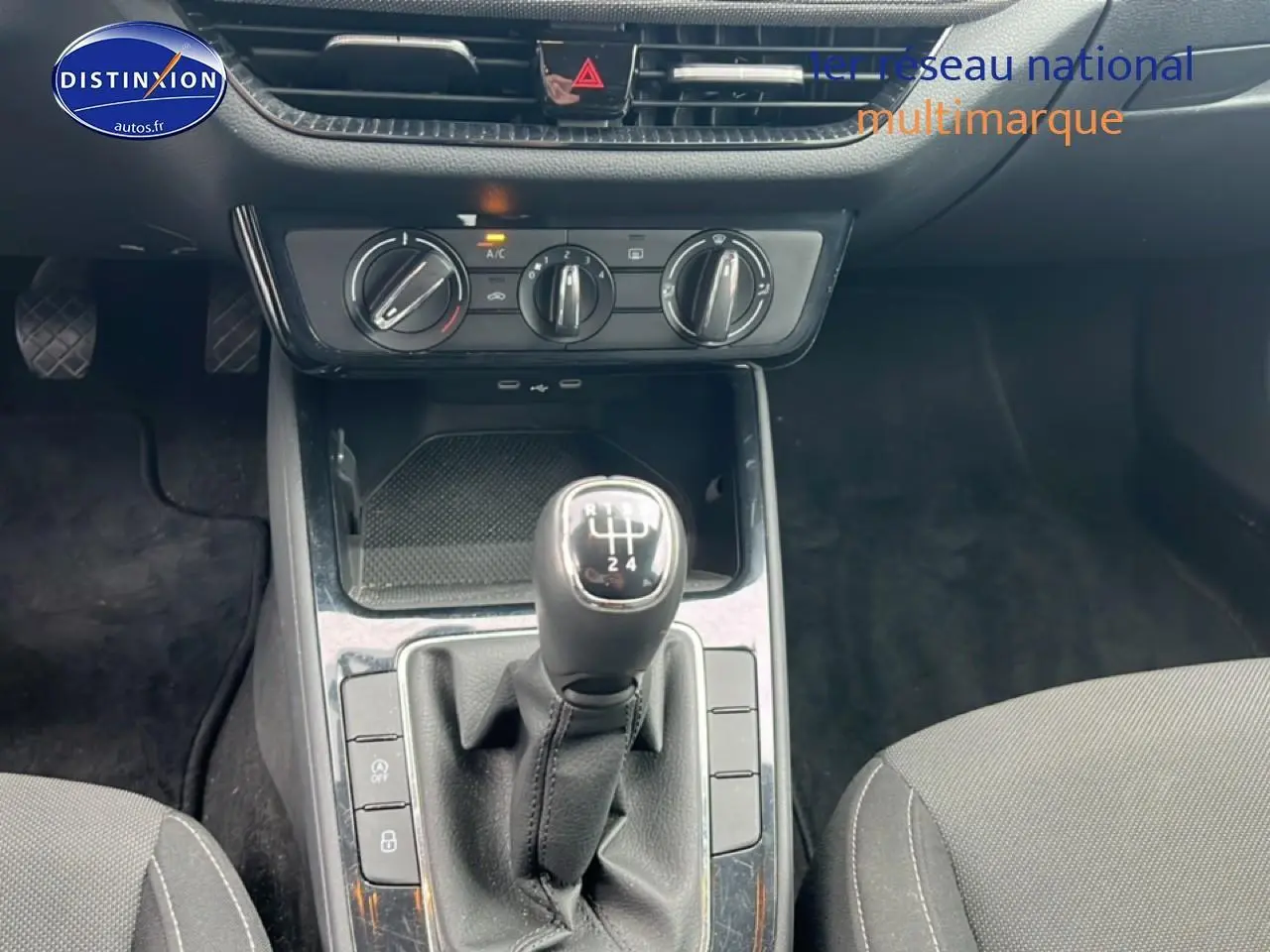 Vue rapprochée de la console centrale avec levier de vitesse manuel et commandes de climatisation d'une Skoda Fabia blanche.